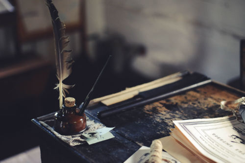 Poesía. Ink bottle on desk. Photo by Clark Young on Unsplash