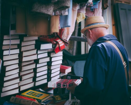 Hombre sosteniendo libros. Foto Clem Onojeghuo en Unsplash